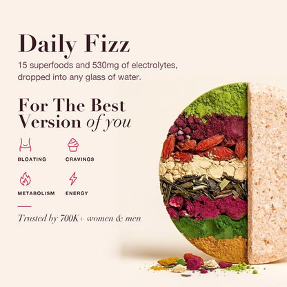 A Superfood Tabs tablet cut in half showing fifteen coloured superfood layers pressed inside, beside the benefits it supports: bloating, cravings, metabolism and energy