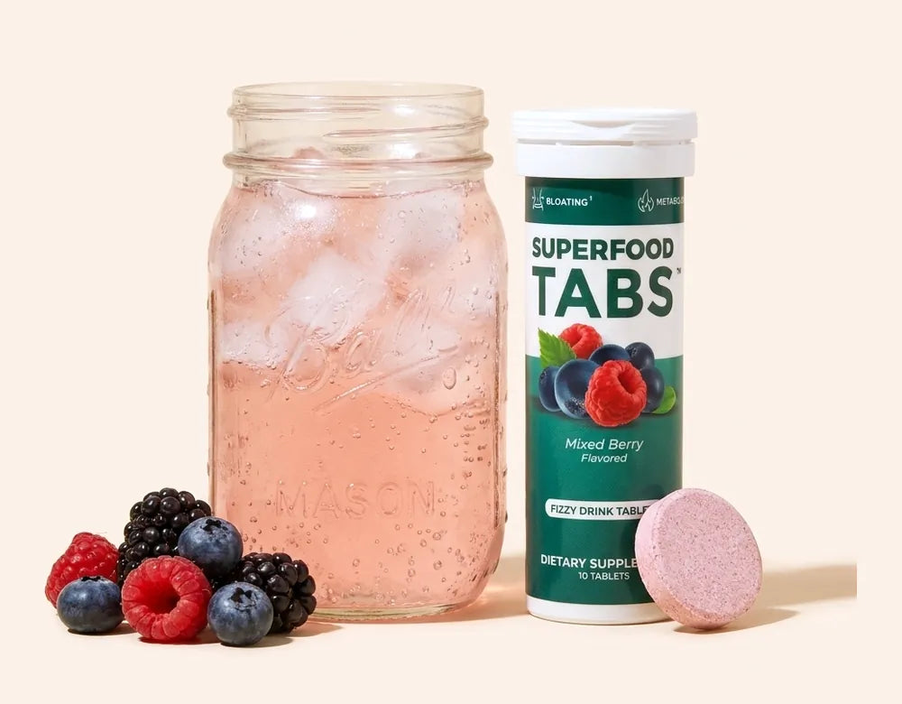 A mason jar of Mixed Berry Superfood Tabs beside its tablet tube